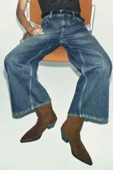 Botín de mujer color marrón de serraje con elásticos laterales, tirador trasero y acabado en punta.