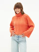 Sweater tejido color naranja oscuro, con cuello alto y mangas largas acampanadas.