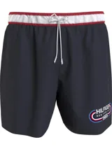 Short de baño azul marino con cintura elástica a rayas blancas y rojas, cordón ajustable y logo de Tommy Hilfiger estampado en la pierna.