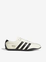 Zapatillas Adidas Tokyo de cuero color crema con detalles en negro, incluyendo las tres tiras laterales y la suela.