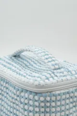 Neceser rectangular con cierre de cremallera, confeccionado en tejido de toalla con textura de motitas en color blanco y rosa pastel.