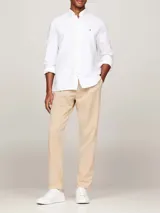 Camisa blanca de algodón Oxford con cuello abotonado, mangas largas y logo de Tommy Hilfiger bordado en el pecho. Corte regular.