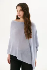 Poncho color beige de tejido de punto con cuello asimétrico.