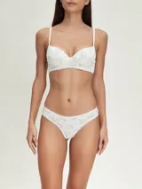 Conjunto de ropa interior femenina de algodón, compuesto por un corpiño con aro y una bombacha tipo bikini. Ambos son de color blanco con estampado floral en tonos celeste y naranja.