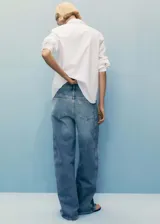 Pantalón de jean celeste de tiro alto, corte balloon, con cinco bolsillos, trabillas y cierre frontal con cremallera y botón.