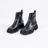 Botas cortas color marrón de cuero vacuno con suela track negra de goma. Presentan cierre lateral con cremallera YKK y puntera cuadrada.