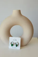 Aros de acero quirúrgico hipoalergénico con forma de argolla plateada y dije circular colgante de piedra natural color azul.