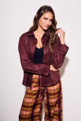 Camisa color marrón de gamuza sintética, de corte recto, con cuello clásico, cierre frontal con botones y mangas largas.