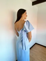 Vestido largo color salmón de un solo hombro, con manga corta abullonada y falda con abertura lateral y volados.