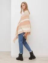Poncho de tejido de punto color beige y salmón con diseño de rayas diagonales y cuello en V. Presenta terminación con flecos en el ruedo.