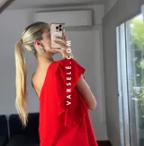 Vestido corto color verde lima, con escote asimétrico a un hombro, volado en el hombro y elástico en el borde superior.