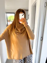 Sweater color tostado, de corte amplio y cuello alto con detalle drapeado.