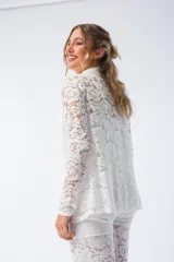 Camisa blanca de encaje con cuello camisero y cierre frontal con botones.