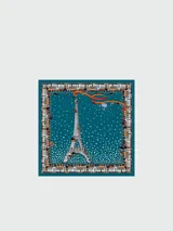 Pañuelo de seda azul con estampado de estrellas blancas y motivos de la Torre Eiffel en tonos marrones y rojos.