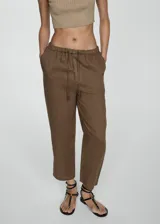 Pantalón negro de lino con diseño crop y jogger, tiro medio, cintura elástica con lazo, dos bolsillos laterales y dos bolsillos de ribete en la parte posterior.