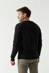 Sweater negro de manga larga con escote en V y logo bordado.