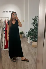 Vestido negro de tejido suave con diseño fluido y escote en V, confeccionado en Uruguay.