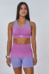 Conjunto deportivo fucsia con degradé lila, compuesto por un top con logo 'bk.' y un short de calce ajustado.