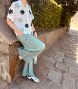 Camisa blanca con bordados de flores negras, de corte oversized y mangas cortas.