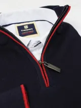 Sweater azul marino de hilo con medio cierre frontal con cremallera y detalles en rojo en cuello y puños.
