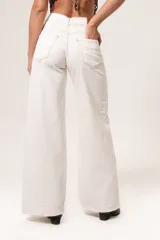 Pantalón de jean color blanco, de tiro medio-alto y corte wide leg.