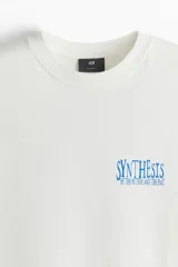 Remera blanca de algodón con cuello redondo y corte holgado. Estampa azul con la palabra 'SYNTHESIS' y texto inferior.