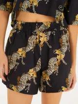 Short negro con estampado de cebras y hojas color ocre, de tela liviana y cintura elástica.