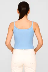 Musculosa blanca de algodón con elastano, breteles finos, corte cropped, cuello redondo y bordado frontal con texto y flores.