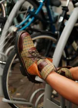 Botas de caña media con plataforma, confeccionadas en tweed a cuadros rojos y negros, con detalles en cuero marrón y cordones marrones.