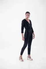 Mono largo negro con lentejuelas, escote en V cruzado, mangas largas y corte ajustado.