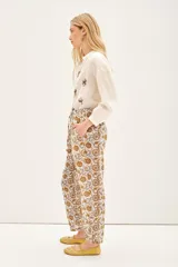 Pantalón babucha de voile de algodón con estampado floral en tonos ocre y marrón. Tiene lazos internos en el ruedo para ajustar el largo.
