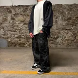 Pantalón super baggy con estampado camuflado en tonos grises y negros.