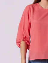 Blusa de gasa color blanco con estampado de hojas verdes, de mangas 3/4 abullonadas con puños elásticos.
