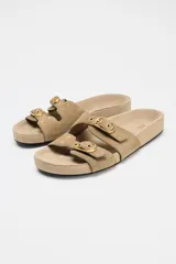 Sandalia plana color beige de serraje con doble tira delantera y hebillas.