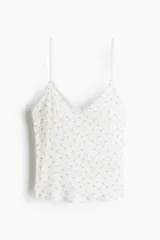 Top blanco de punto pointelle con estampado floral en tonos rosados, escote en V y breteles finos regulables.