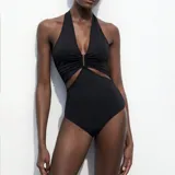 Body negro con escote halter, abertura en la cintura y espalda descubierta.