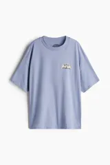 Remera celeste de corte amplio con cuello redondo y estampado pequeño en el pecho.