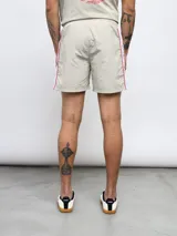 Short de baño negro con una franja vertical celeste con diseño estampado en el lateral.