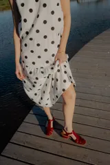 Vestido midi blanco con estampado de lunares negros, sin mangas y corte holgado.