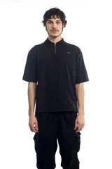 Remera polo negra de manga corta con cierre dorado en el cuello y logo bordado en el pecho.