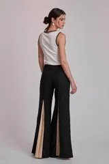 Remera negra ajustada al cuerpo, tipo musculosa, con escote redondo y ribetes en blanco con apliques de perlas en el contorno del cuello y las sisas.