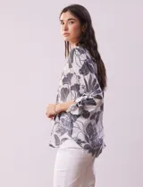 Blusa de gasa estampada con cuello a la base, escote en V y botones. Delantera con detalle plisado y largo de manga regulable con presilla y botón.