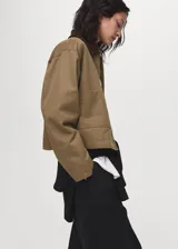 Chaqueta de algodón estilo tejano en color tostado, con diseño recto y manga larga con puños abotonados. Destaca por su cuello camisero de pana en contraste de color marrón oscuro, cierre frontal con botones y dos bolsillos de parche en el frente. Cuenta con forro interior.