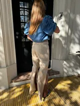 Pantalón sastrero color beige de lino, corte recto y tiro alto, con bordado de caballo en el bolsillo trasero.