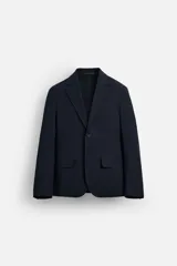 Blazer azul marino de corte recto, con cuello de solapa de muesca, cierre frontal con dos botones, bolsillos de solapa en la cadera y aberturas en la espalda. Confeccionado en tejido de algodón con elasticidad y sin forro interior.