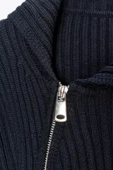 Chaqueta de punto rib color azul marino, con cuello solapa, manga larga y cierre frontal asimétrico con cremallera metálica.