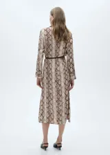 Vestido midi de viscosa con estampado de piel de serpiente en tonos beige y marrón. Tiene cuello camisero, cierre frontal abotonado, cinturón decorativo, mangas largas con puños abotonados y bolsillos de parche.