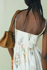 Vestido midi blanco con estampado floral multicolor, escote cuadrado y breteles finos ajustables.