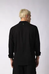 Camisa de manga larga color beige claro, con cuello abierto y calce relajado.