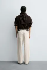 Pantalón de jean color crudo con textura de rayas verticales, corte relaxed fit, tiro medio, cinco bolsillos y cierre frontal con cremallera y botón.